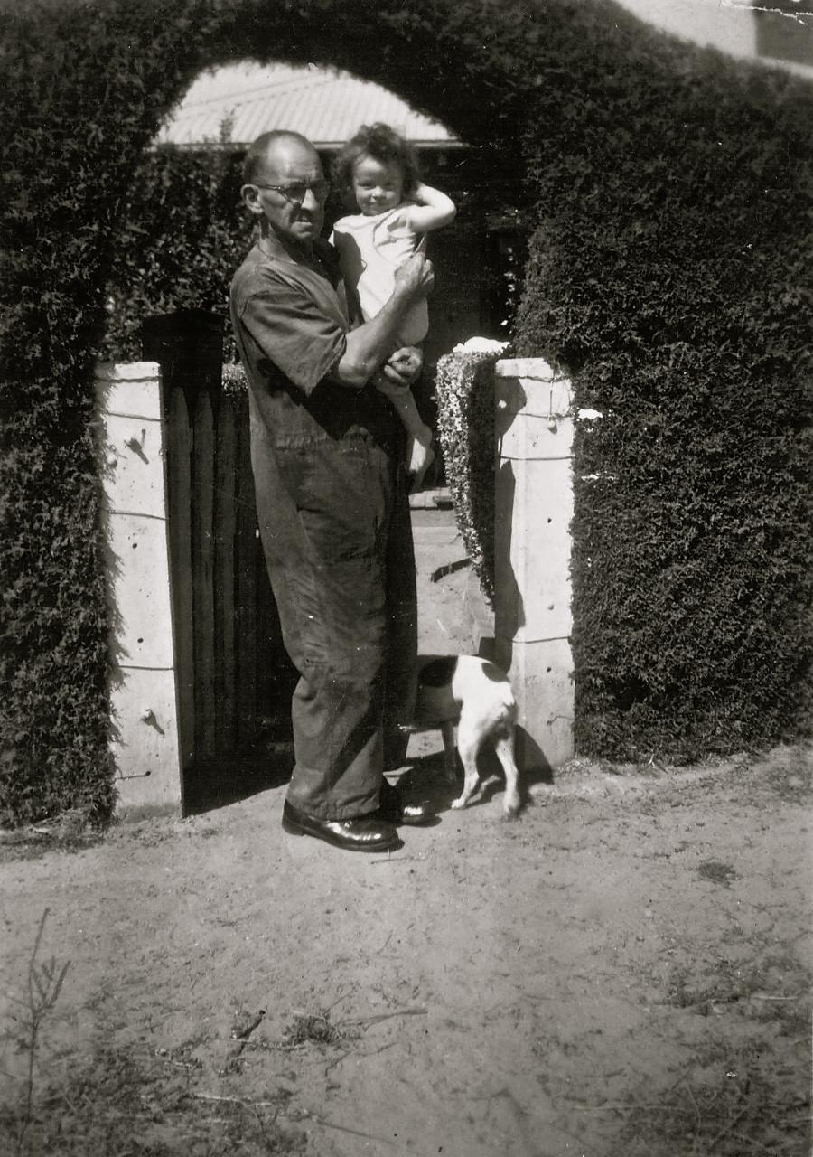 William McNamee with grandchild outside front gate no. 12 Acton cottages