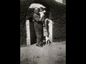 William McNamee with grandchild outside front gate no. 12 Acton cottages